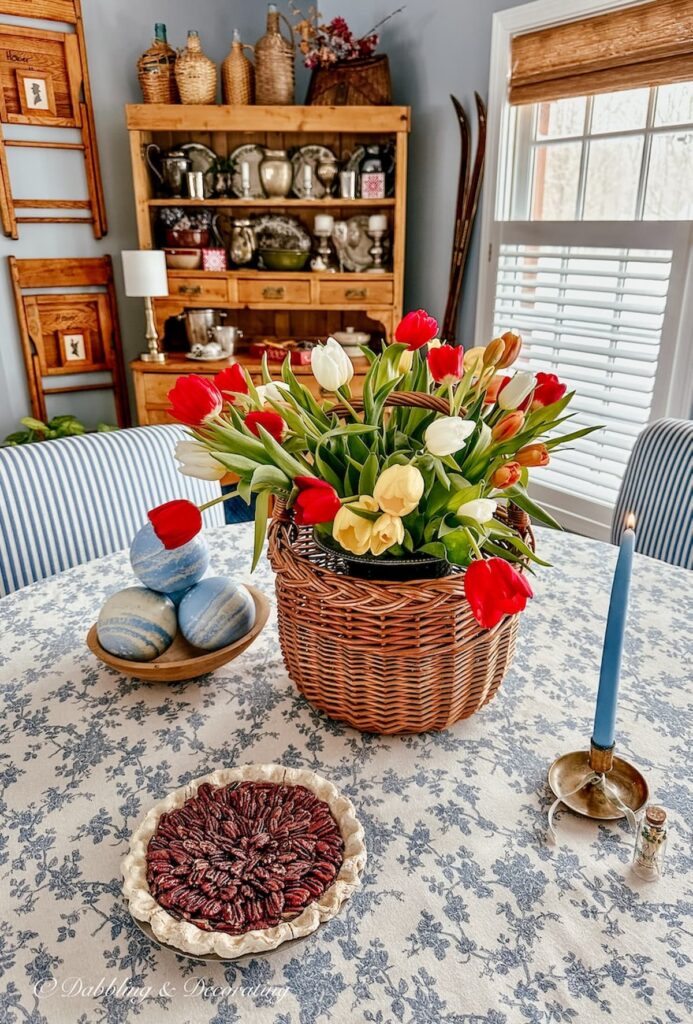 Tulip arrangements in a basket with red, yellow, white on dining room table centerpiece.
