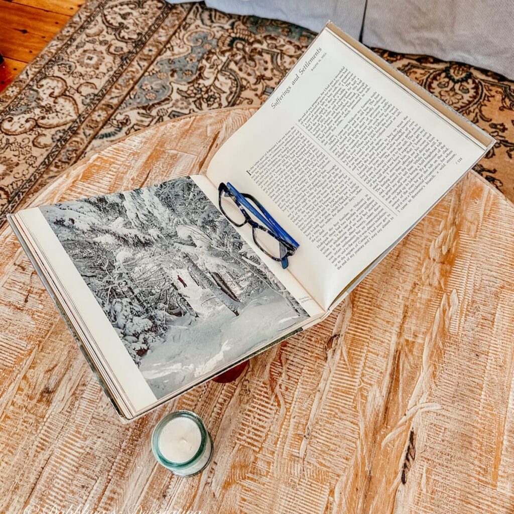 Open vintage book on book rest on coffee table.