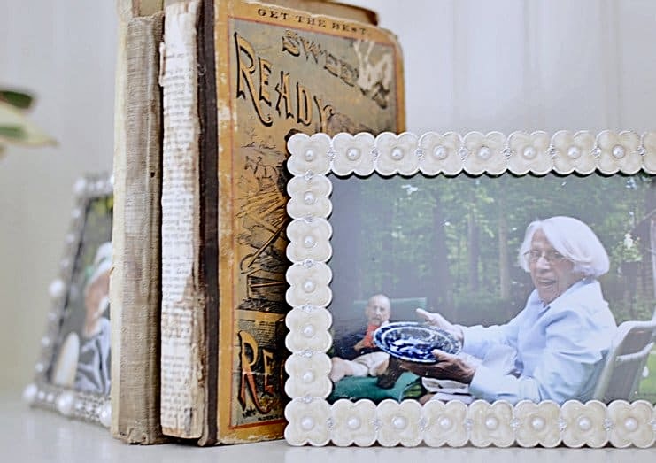 Photos as bookends for old books decor on bookshelf.