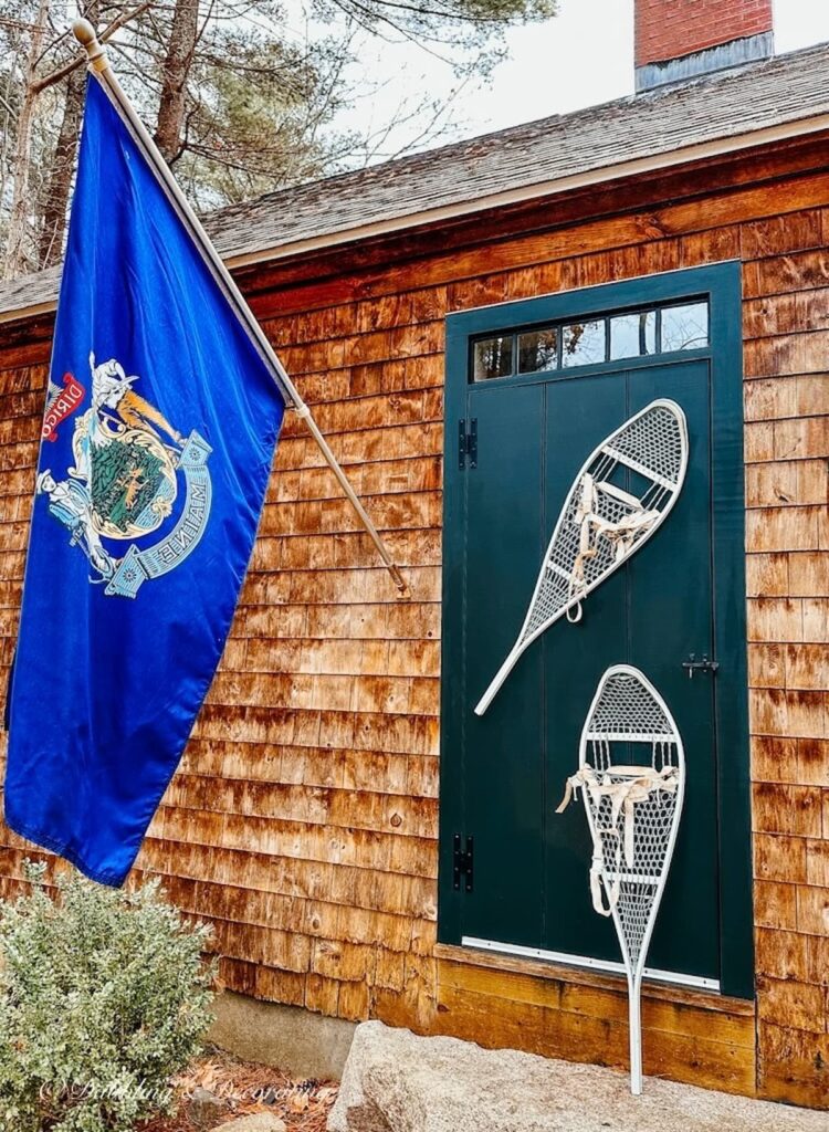 White Metal Snowshoes on Front Door with Maine Flag