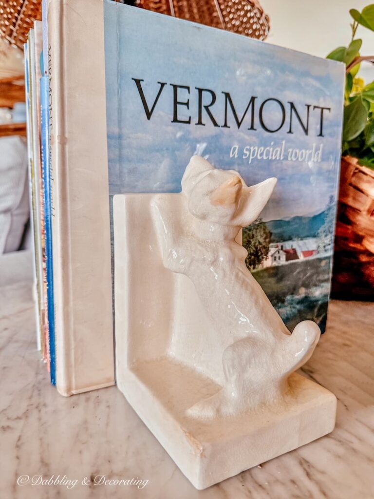 White westie dog bookends in porcelain antique from Paris with Vermont book on table.