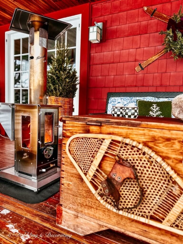 wood pellet outdoor stove on covered porch with snowshoe.