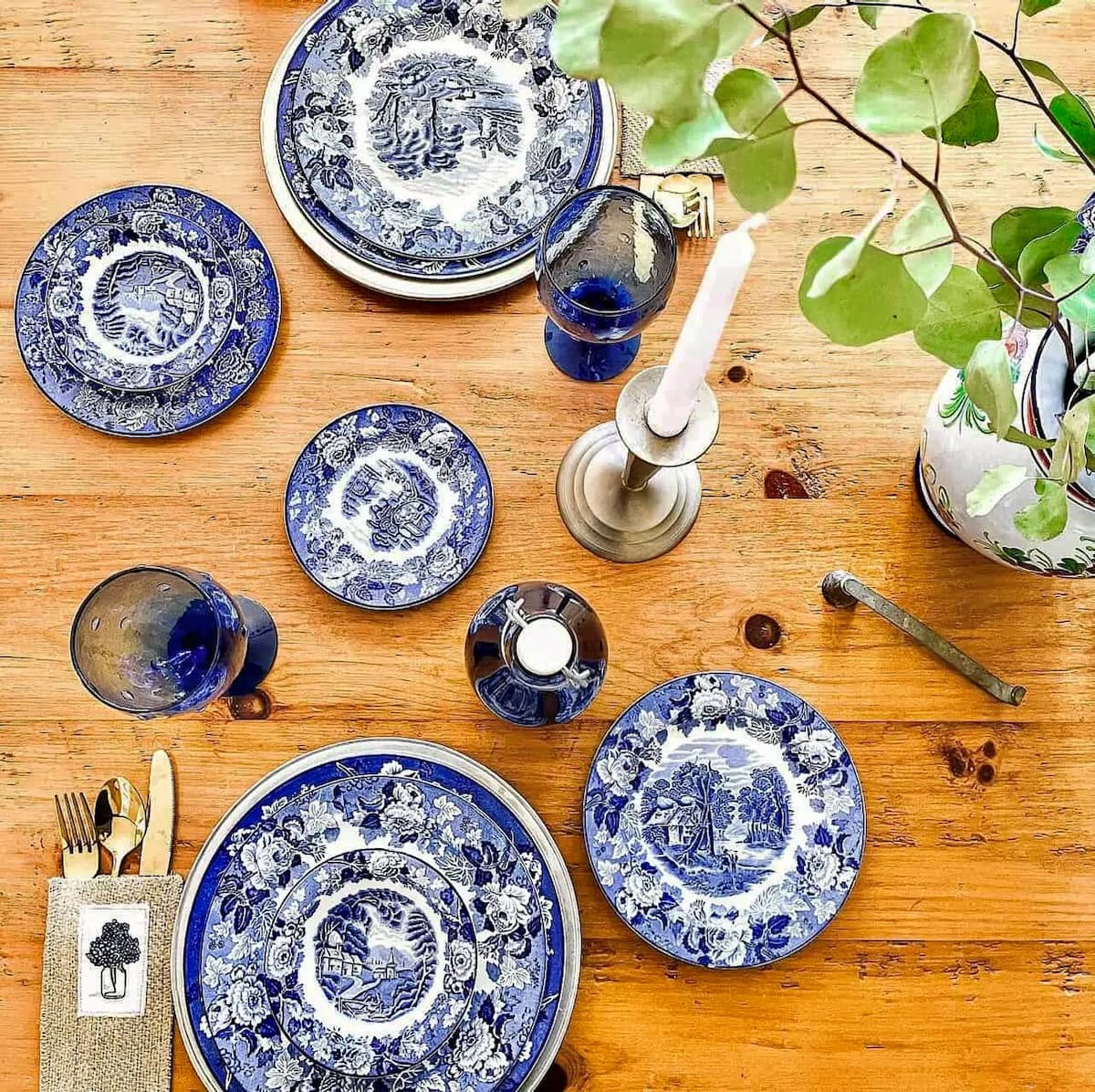 Blue and white gifts for her with a table setting of vintage blue and white dishes, blue glassware and silverware pouches.