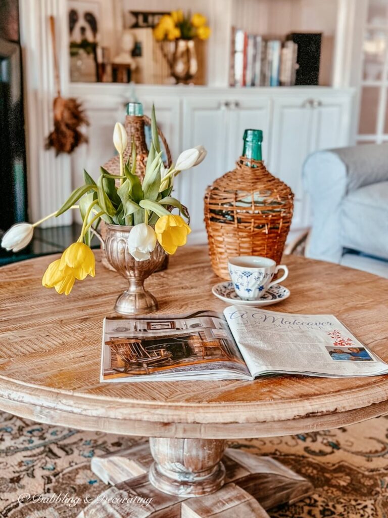 Coffee Table with Demijohn magazine and spring tulips in living room.