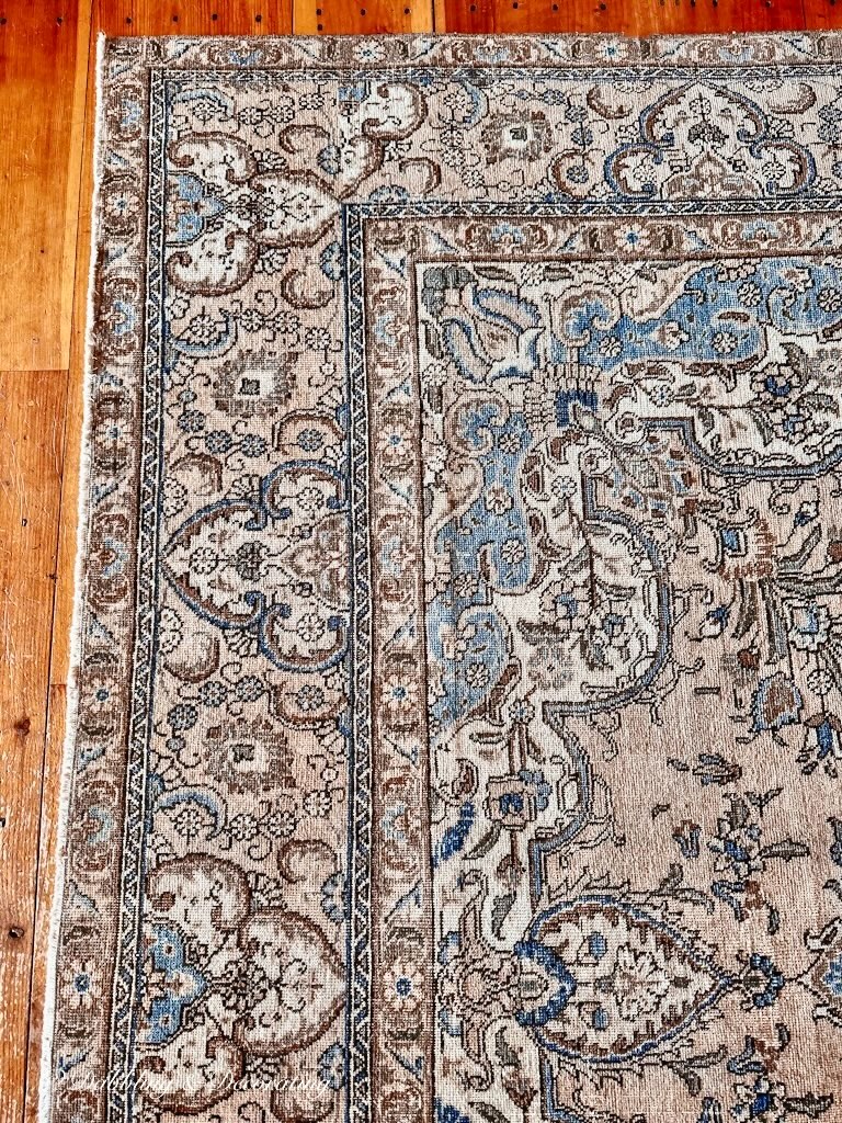 Vintage Turkish Rug by Revival on wood flooring in living room.
