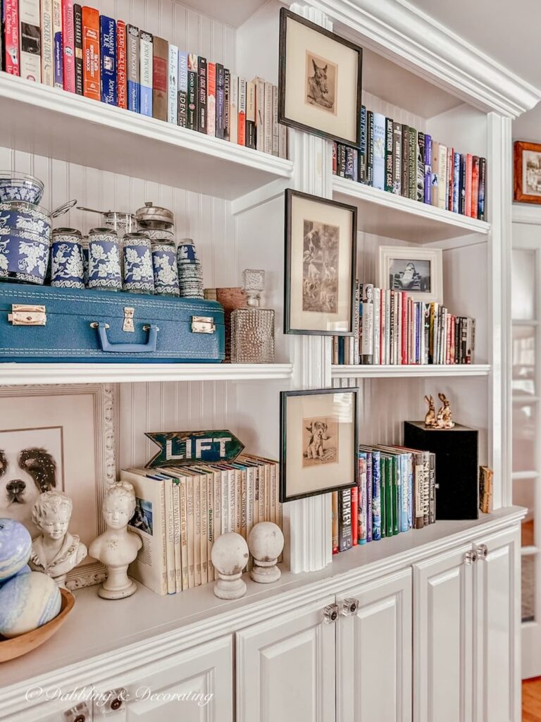 Vintage styled winter bookshelves with blue suitcase and dog prints.