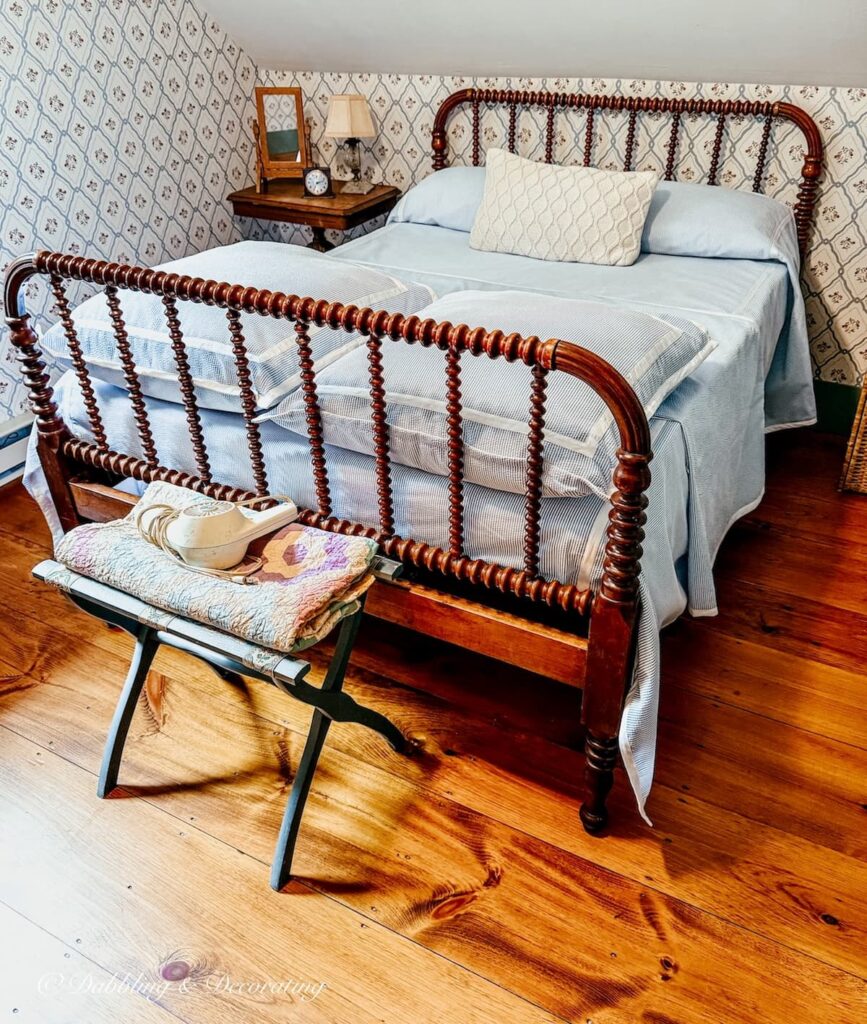Vintage Jenny Lind bed with seersucker bedding in Maine attic bedroom.