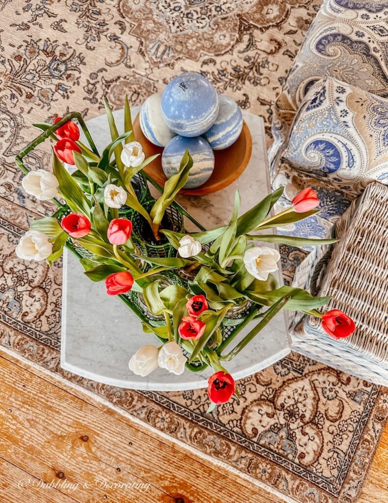 Tulips in Gardening Carry and Vintage Trophy Bowling Bowls on Marble Table.