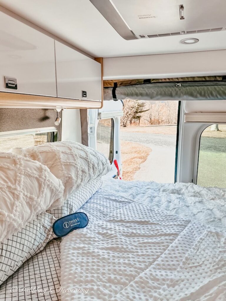 RV Bed with Open Back Door Looking at Mountains.