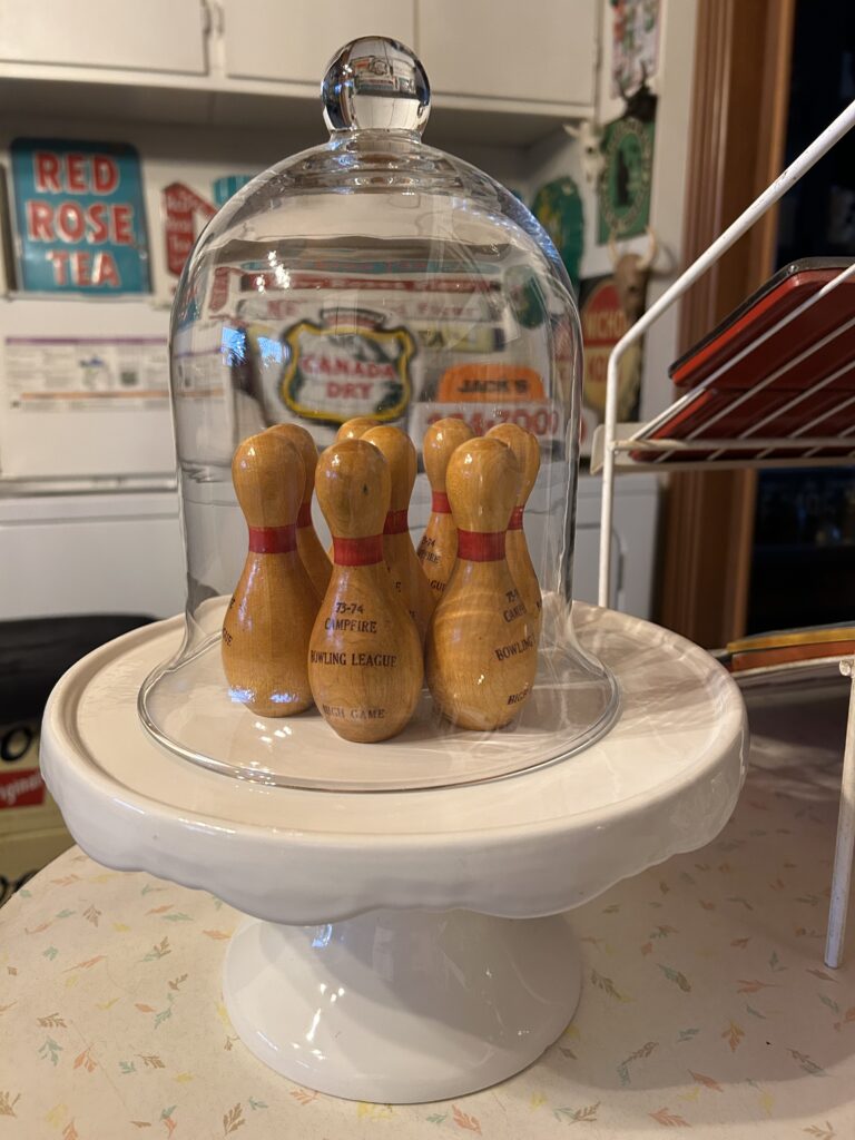 Miniature bowling pins under cloche