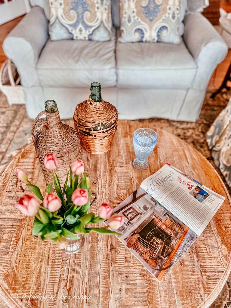 Living room coffee table with pink tulips and demijohns.