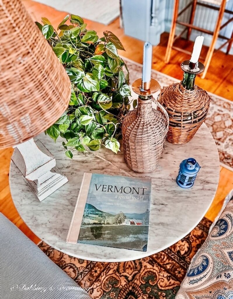 Marble Side Table with Plant Decor, Demijohn's Coffee Table Book and Lamp in Living Room