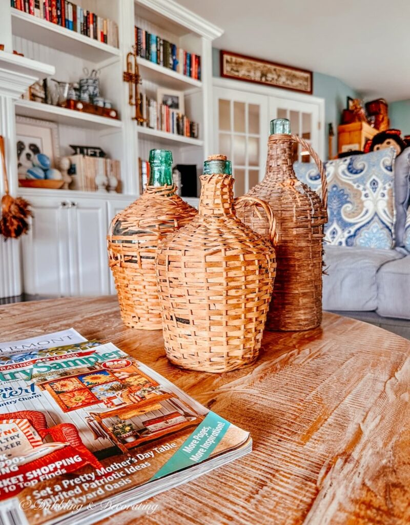 Three demijohns and magazine on living room coffee table.