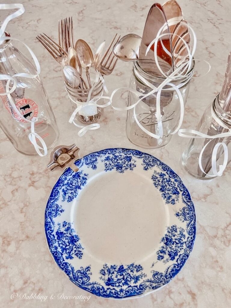 Vintage Silverware in Mason Jars with Blue Dish on Counter.