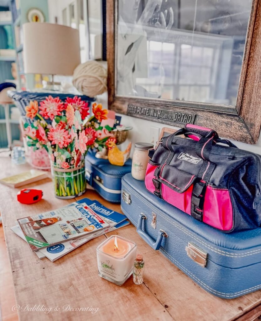 Eclectic decor on craft room table with vintage marketplace suitcases