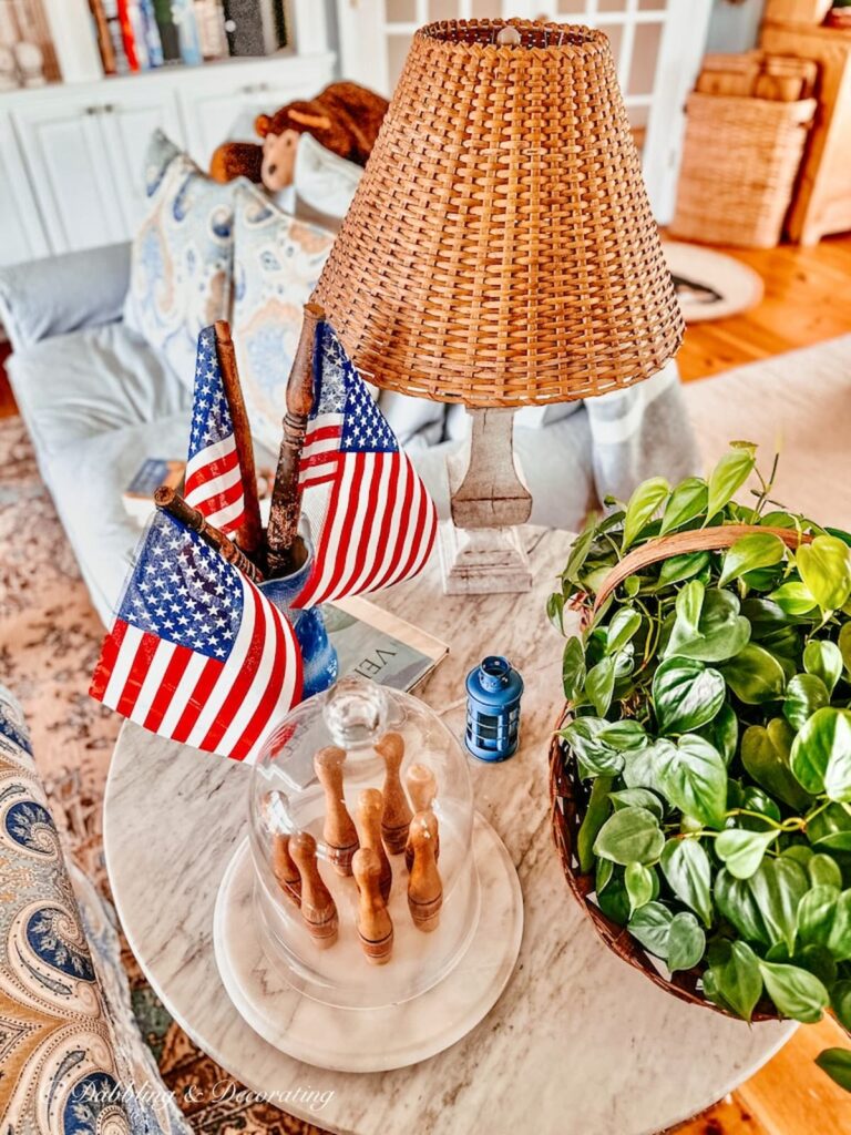 DIY American Flags made out of spindles in Vintage blue vase on table in vintage Americana decor ideas.