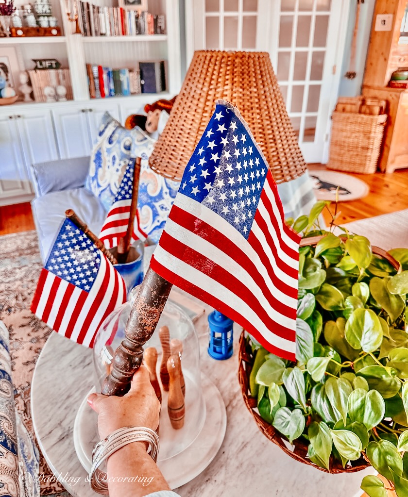 DIY American Flags made out of spindles in Vintage blue vase on table.