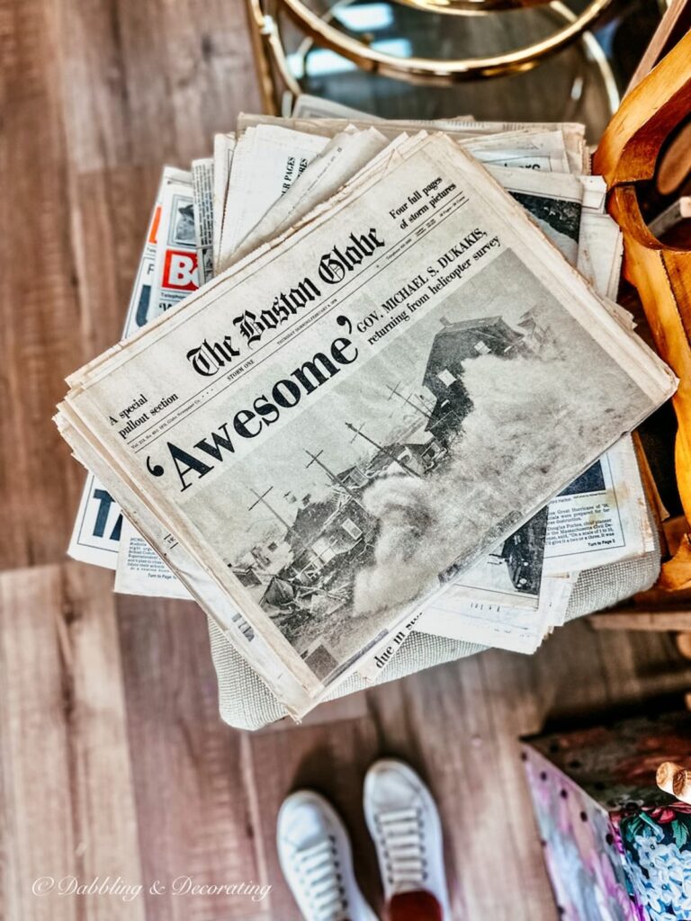 Stack of vintage newspapers with storm headlines in thrift store.