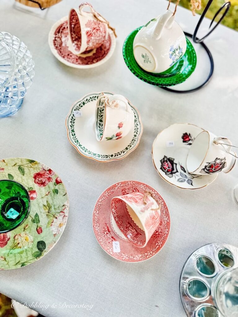 red and white teacup bird feeders on thrift store table.