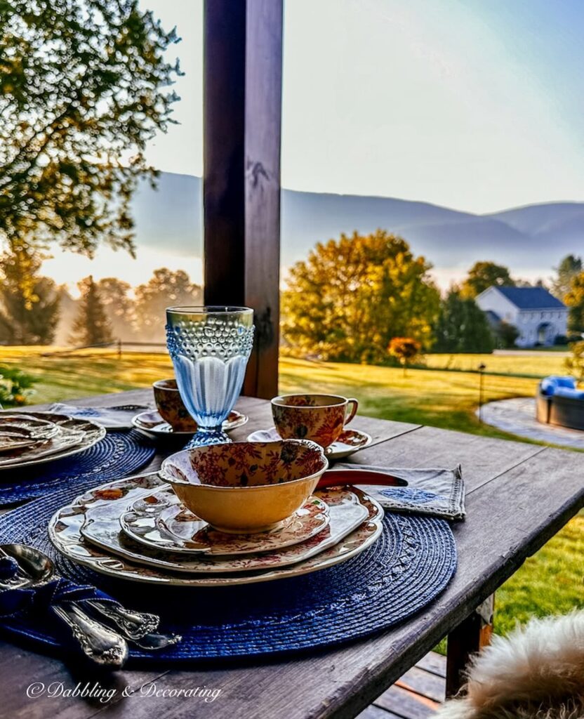 Fall place setting on porch with foliage mountain views during misty morning in Vermont.