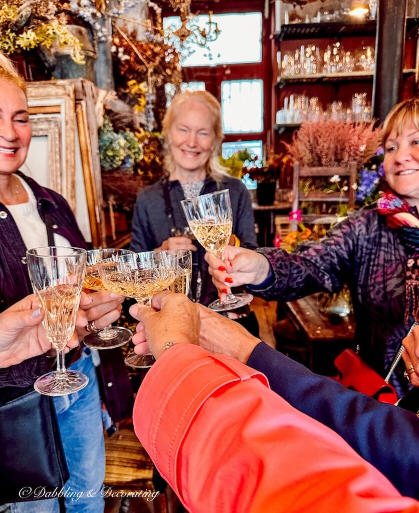 Women with champagne glasses toasting in a flower shop in Paris France.