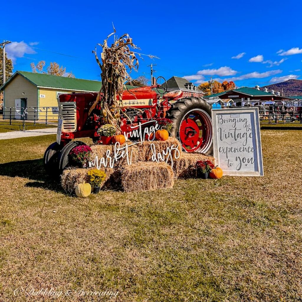 Red tractor with hay bales at entry point of Vintage Market Days Vermont.