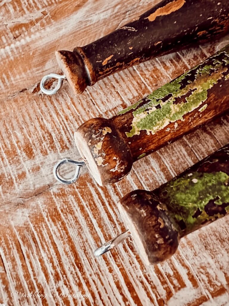Three vintage spools with eye screw at the end of each.
