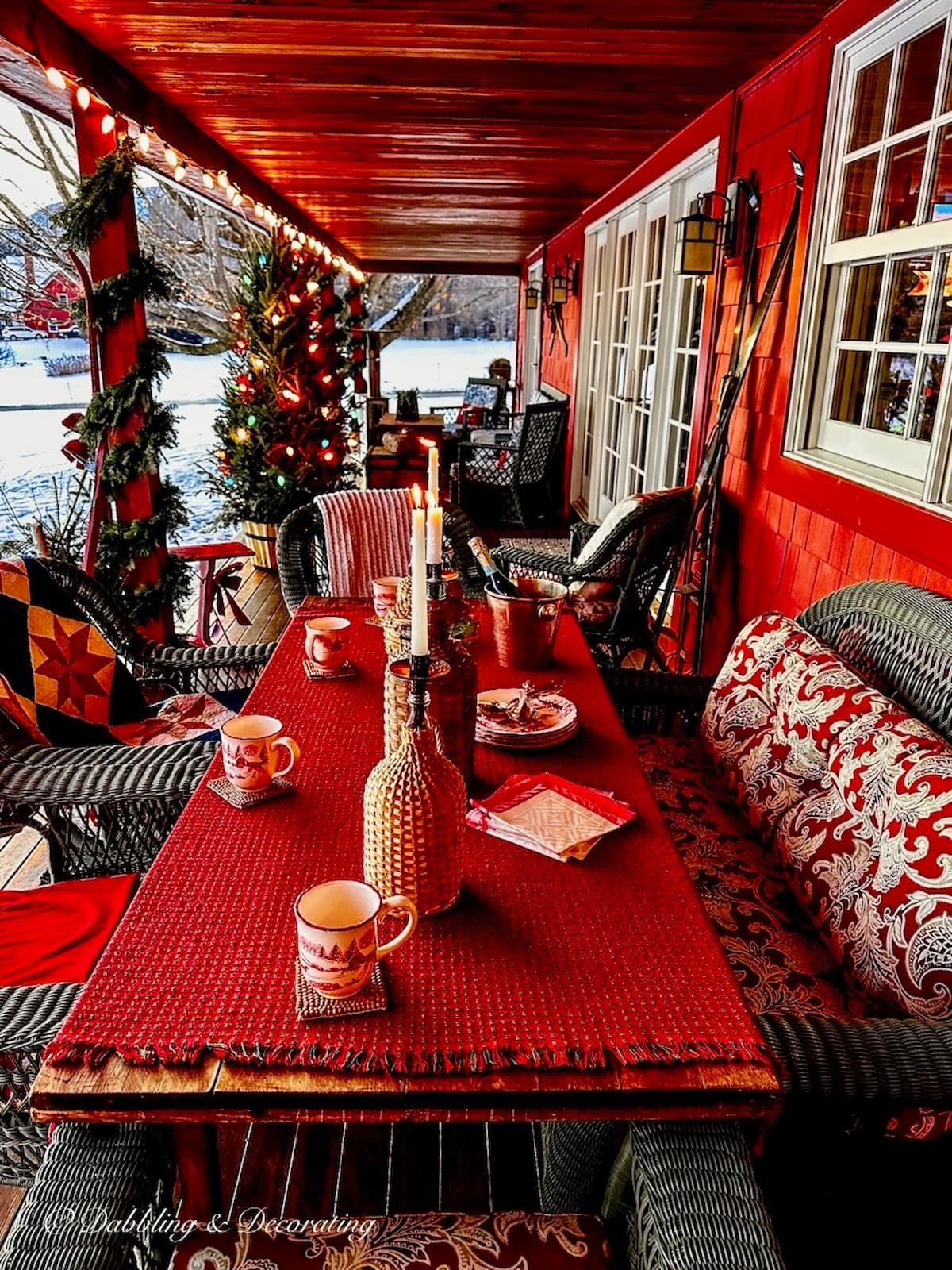 Apres ski themed party porch after Christmas decorated in red with Christmas lights on porch. Vintage Skis for Decoration.