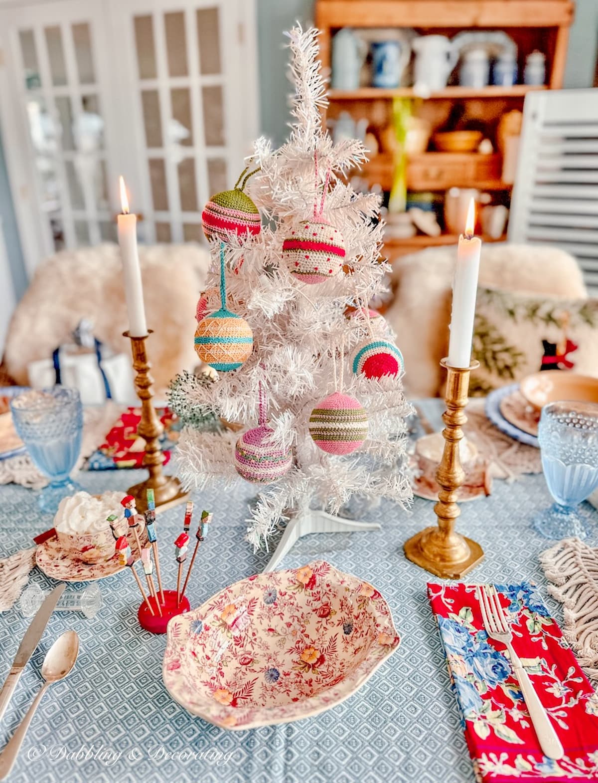 Vintage white small Christmas tree on light blue tablescape with Christmas details.
