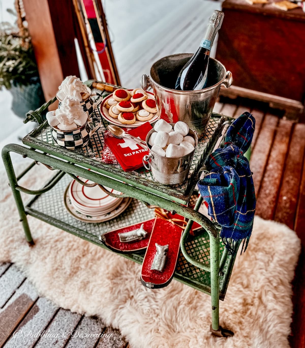 Antique bar cart set up for apres' ski themed party on wintery snowy porch on sheepskin rug.