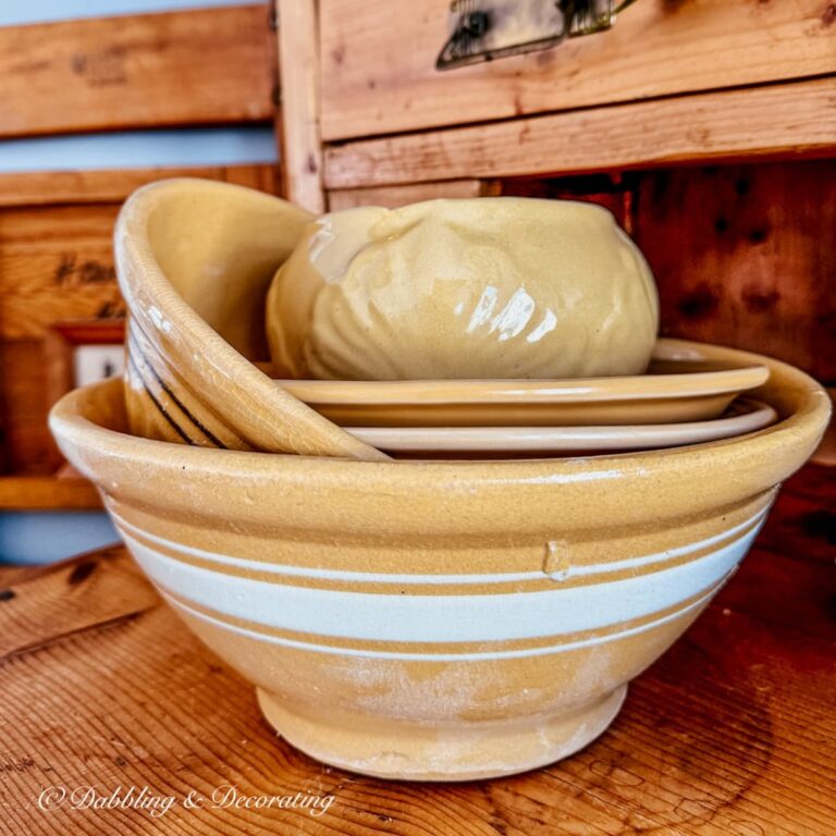 Yellowware bowls stacked on pine vintage hutch.