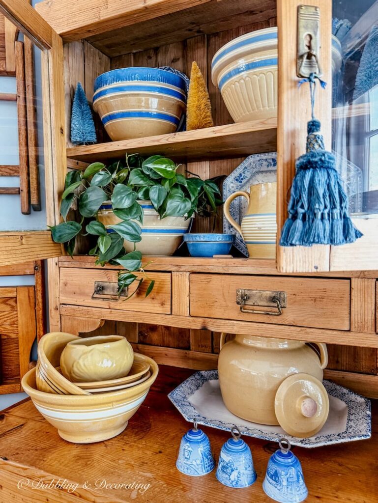 Vintage pine hutch filled with yellowware bowls along with pitchers and other small collectibles.