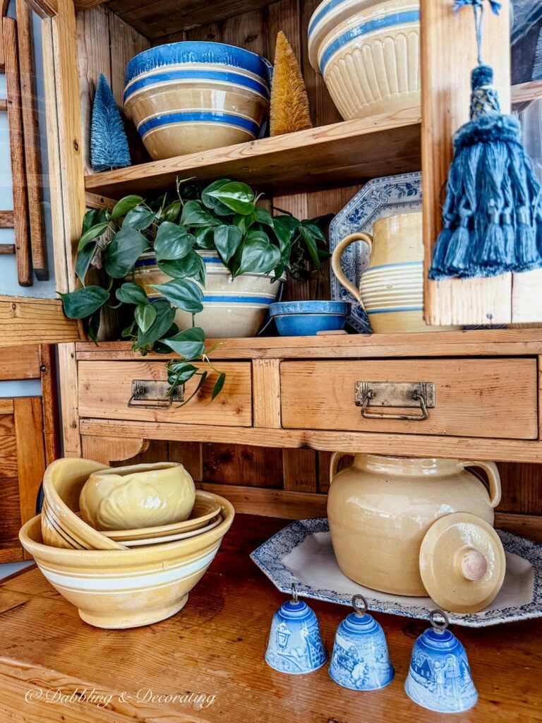 Vintage pine hutch filled with yellowware bowls along with pitchers and other small collectibles.