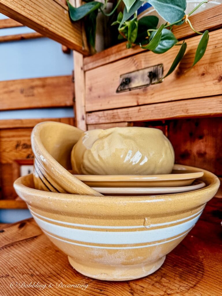 Yellowware bowls stacked on pine vintage hutch.