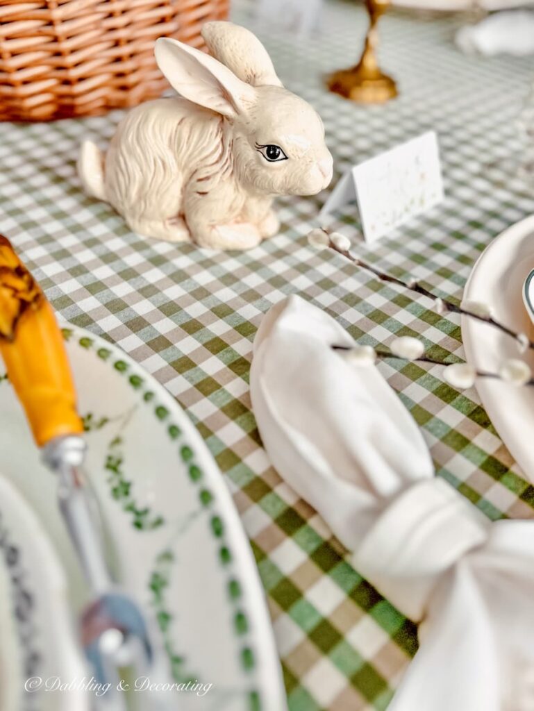 Easter white bunny on a green and white gingham table cloth on Easter tablescape.