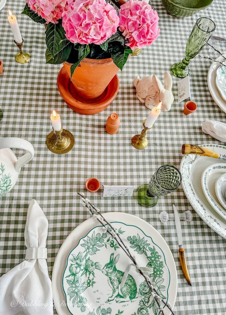 Green and white tablescape with terracotta pot centerpiece with pink hydrangeas.