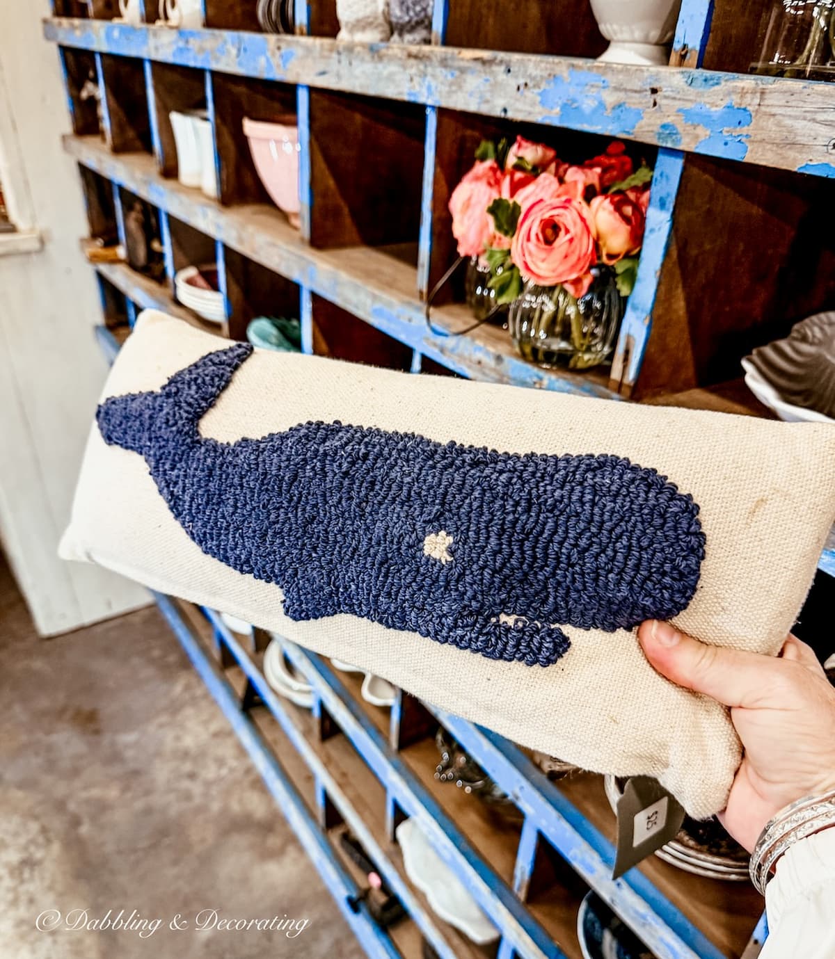 Vintage lumbar pillow with blue whale in hand.