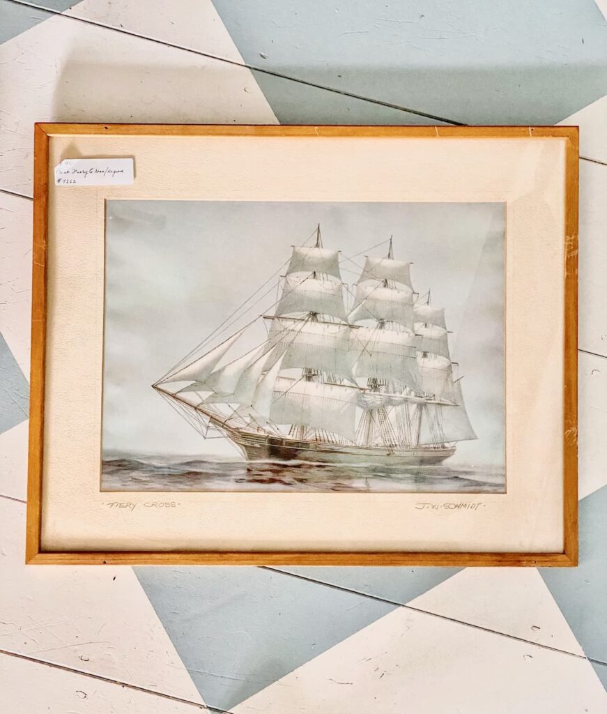 Vintage pastel sailboat print in wooden frame.