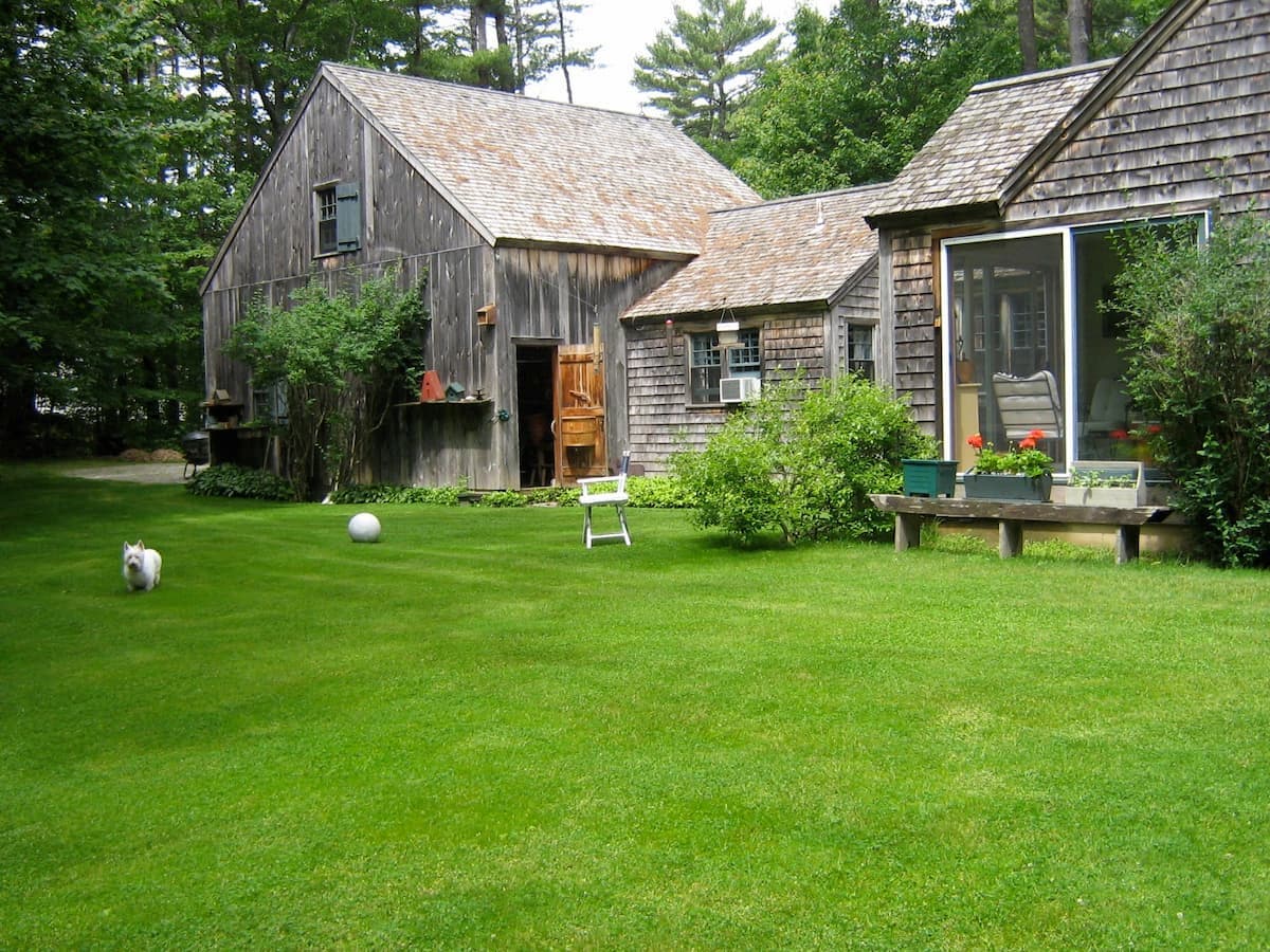 Maine home in 2009 backyard view of cedar shakes home in summer.