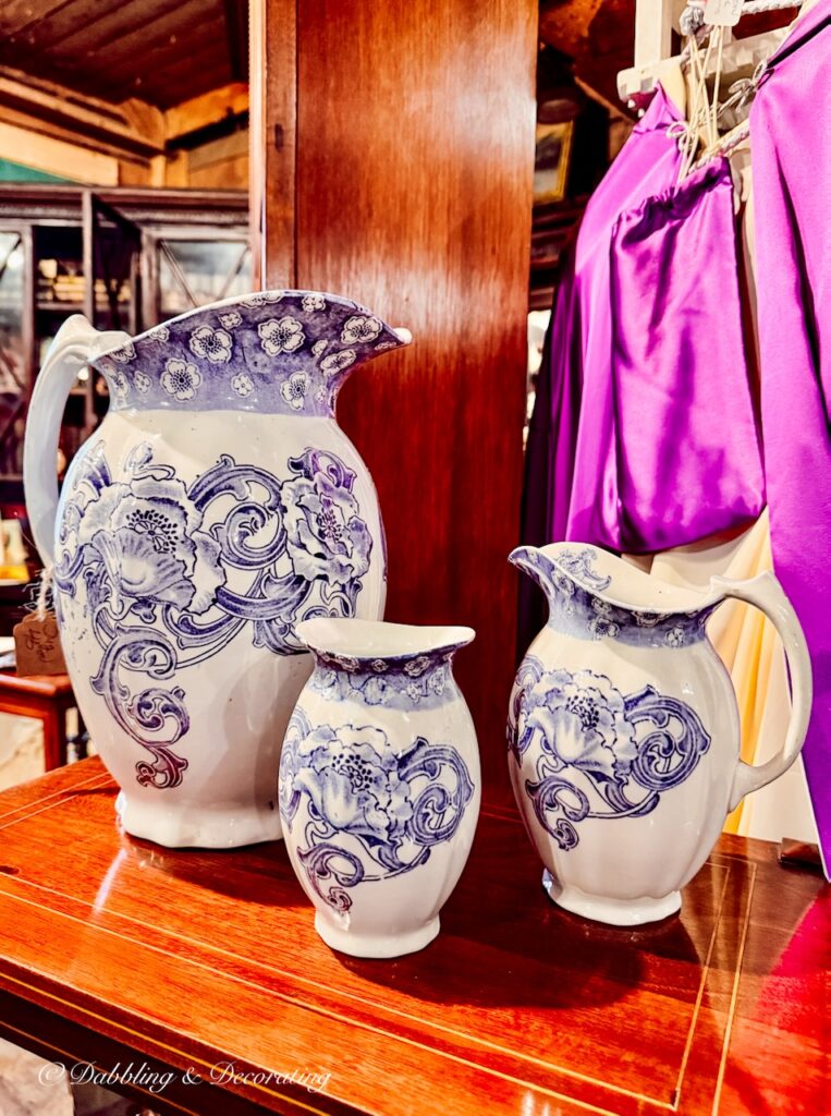 Purple and white vintage transferware pitchers in antique store.