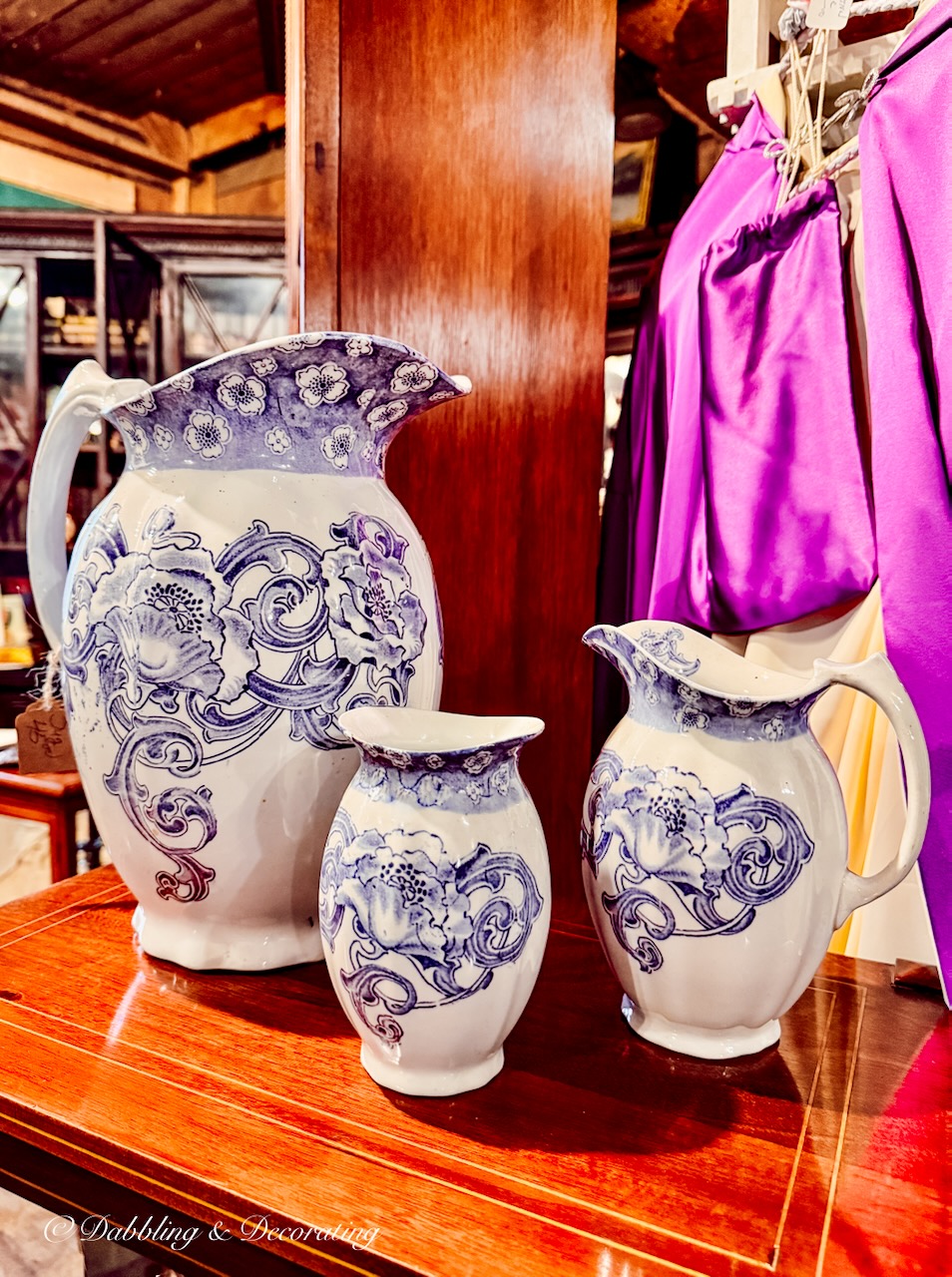 Purple and white vintage transferware pitchers in antique store.