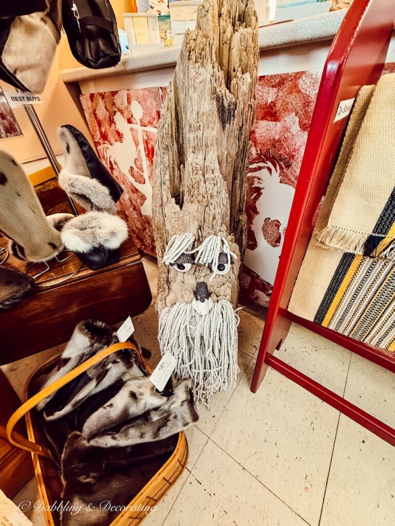 Driftwood turned into a face with rope and eyes in gift shop.