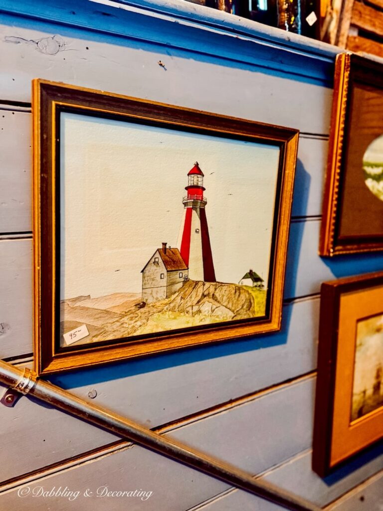 Vintage lighthouse painting in antique store in Nova Scotia for coastal cottage décor ideas.