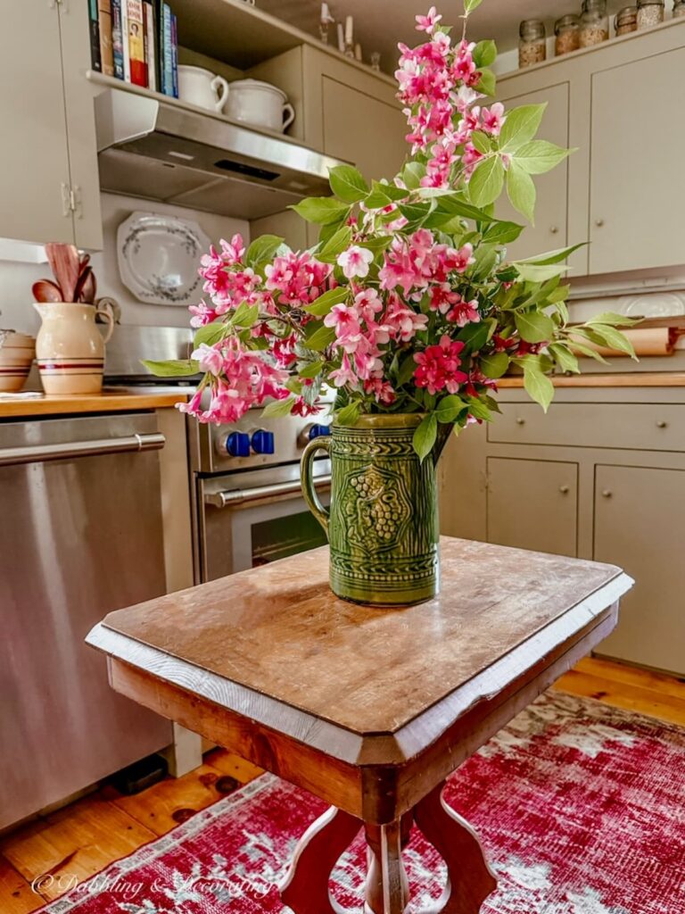 Vintage green McCoy pitcher found at Goodwill New England in Summer Home Decor in kitchen styled with pink flowers.