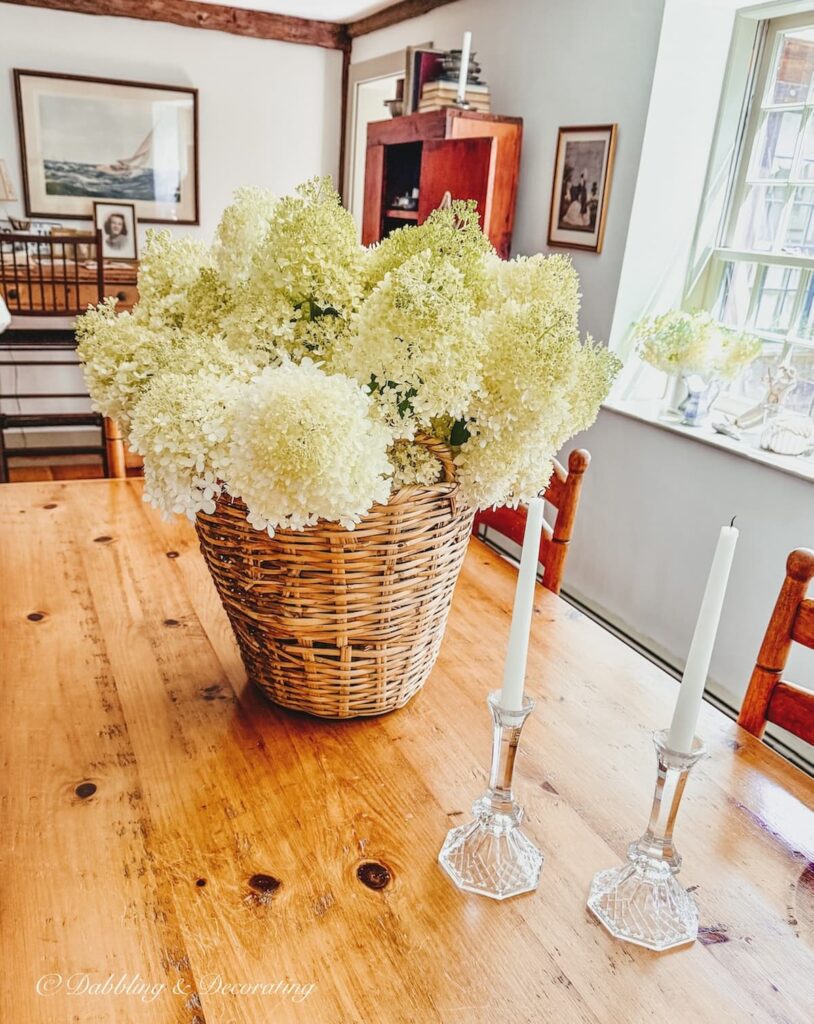 Vintage flower arrangement with limelight hydrangeas in a large basket as table centerpiece, summer table decorations.