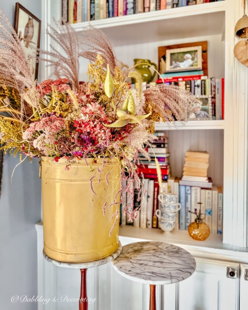 Yellow vintage tin with foraged yellow and pink fall flowers in a vintage flower arrangement.