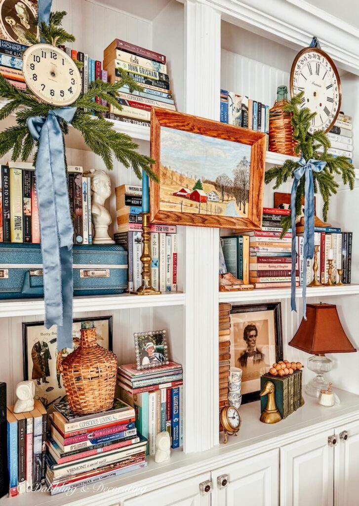 Vintage bookshelf decor ideas for New Years and Christmas with eclectic style and vintage clock faces.