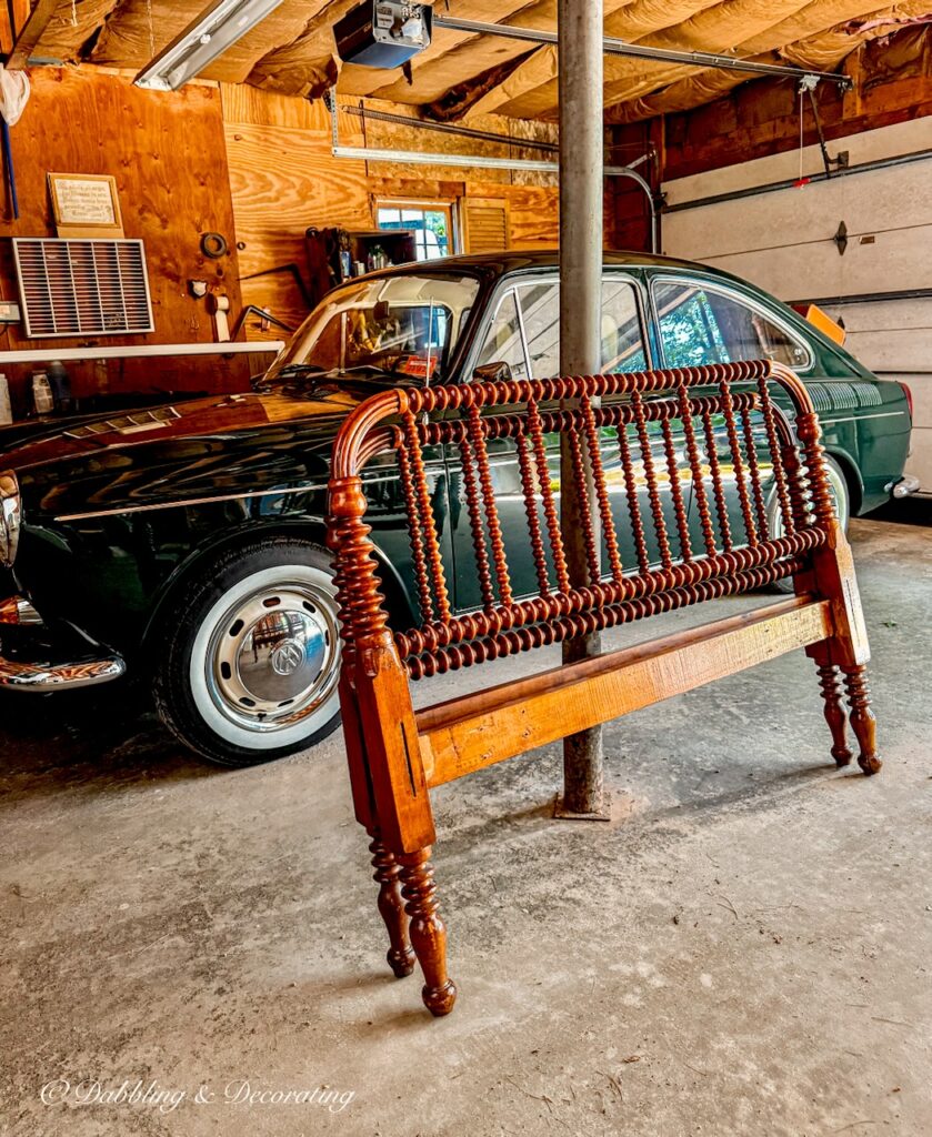 Jenny Lind bed makeover yard sale bed in garage next to antique VW Fastback Car.