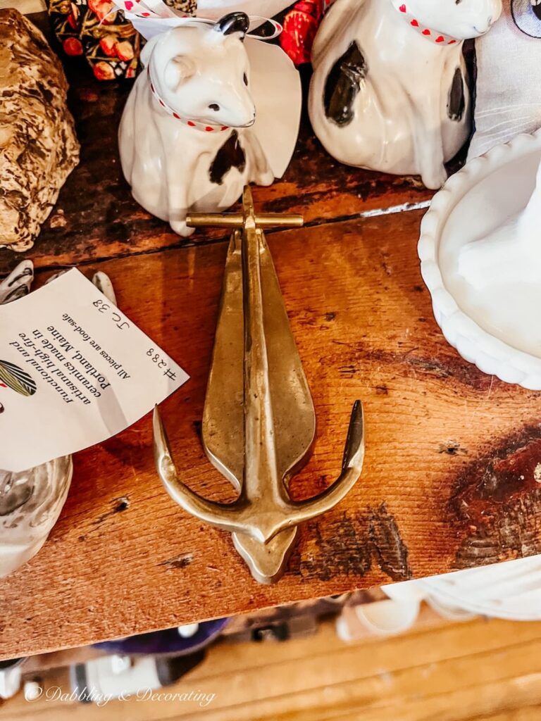 Antique brass anchor door knocker in antique store for vintage coastal decor ideas.