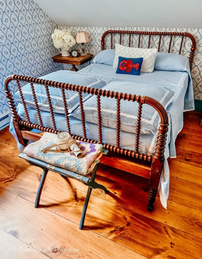 Antique Jenny Lind bed with Seersucker bedding in vintage style coastal home attic.